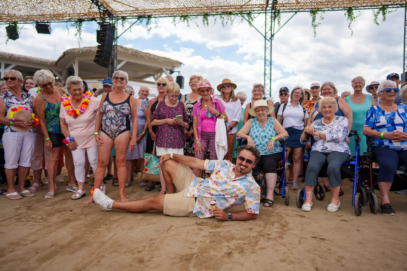 Photo de groupe sur le sable, Dominic couché devant les résidents